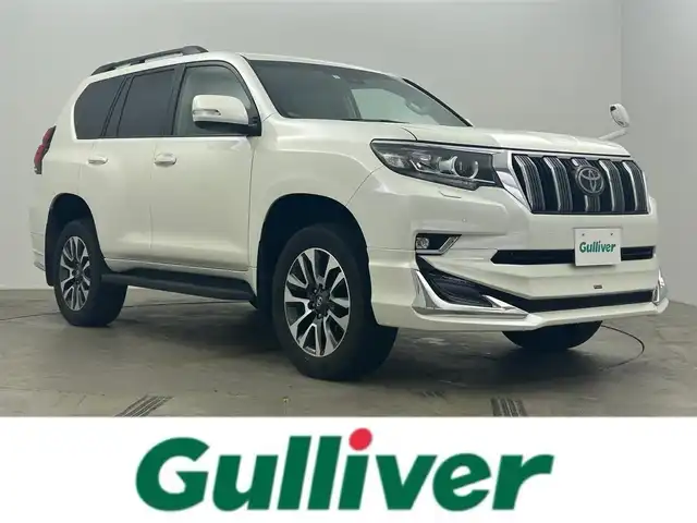 トヨタ ランドクルーザー プラド TX Lパッケージ 岡山県 2023(令5)年 2万km ホワイトパールクリスタルシャイン サンルーフ/モデリスタエアロ（前/後下）/ベージュレザーシート/ルーフレール/純正19インチAW/純正9インチSDナビ/（Bluetooth/フルセグTV)/プリクラッシュセーフティ/レーダークルーズコントロール/踏み間違い防止/オートハイビーム/ＬＥＤヘッドライト（Auto付）/LEDフォグランプ/ビルトインＥＴＣ/バックカメラ/シートヒーター（D/N）/エアシート（D/N）/パワーシート（D/N）/コンビハンドル/ISOFIX/ステアリングスイッチ/チルトステアリング/シートリフター/ウインカーミラー