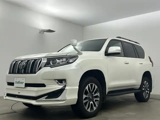 トヨタ ランドクルーザー プラド TX Lパッケージ 岡山県 2023(令5)年 2万km ホワイトパールクリスタルシャイン サンルーフ/モデリスタエアロ（前/後下）/ベージュレザーシート/ルーフレール/純正19インチAW/純正9インチSDナビ/（Bluetooth/フルセグTV)/プリクラッシュセーフティ/レーダークルーズコントロール/踏み間違い防止/オートハイビーム/ＬＥＤヘッドライト（Auto付）/LEDフォグランプ/ビルトインＥＴＣ/バックカメラ/シートヒーター（D/N）/エアシート（D/N）/パワーシート（D/N）/コンビハンドル/ISOFIX/ステアリングスイッチ/チルトステアリング/シートリフター/ウインカーミラー