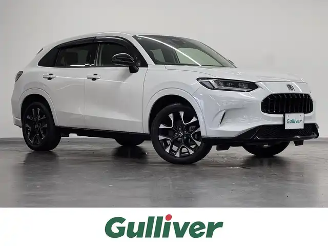 ホンダ ＺＲ－Ｖ ハイブリッド e:HEV Z 三重県 2023(令5)年 3.7万km プラチナホワイトパール ハイブリッド/FF/MTモード付フロアCVT/BOSEプレミアムサウンドシステム（12スピーカー）/Honda Connect対応 9インチナビ/（AM/FM/USB/CarPlay/AndroidAuto/Bluetooth/TV）/マルチビューカメラシステム（360カメラ）/ドライブレコーダー 前方/ビルトイン ETC2.0/Honda SENSING/・衝突軽減ブレーキ［CMBS］/・車線維持支援システム［LKAS］/・路外逸脱抑制機能/・渋滞追従機能付アダプティブクルーズコントロール［ACC］/・アダプティブドライビングビーム［ADB］/・パーキングセンサーシステム/・先行車発進お知らせ機能/・誤発進抑制機能、後方誤発進抑制機能/・トラフィックジャムアシスト（渋滞運転支援機能）/・標識認識機能/・横滑り防止機能/など/装備/・本革シート/・ハンズフリーアクセスパワーテールゲート（予約クローズ機能付）/・パワーシート（Dメモリー付8way/N4way）/・シートヒーター（D/N）/・ステアリングヒーター/・左右独立オートエアコン/・ワイヤレス充電器/・パドルシフト/・純正18inAW/・スマートキーx1/など