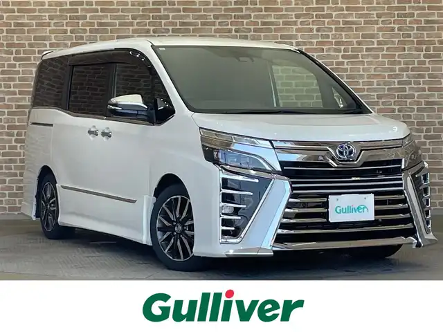トヨタ ヴォクシー ZS 煌Ⅱ 岩手県 2019(令1)年 9.8万km ホワイトパールクリスタルシャイン ４WD/TEIN車高調FLEXA/後席モニター/モデリスタリアスポイラー/ロールサンシェード/両側パワースライドドア/衝突被害軽減システム/横滑り防止装置/MTモード付きAT/寒冷地仕様/アイドリングストップ/クルーズコントロール/バックカメラ/フルセグTV/コーナーセンサー/レーンアシスト/純正ナビ/純正アルミホイール16インチ/純正LEDヘッドライト/社外マット/３列シート/ウォークスルー/オートライト/オートマチックハイビーム