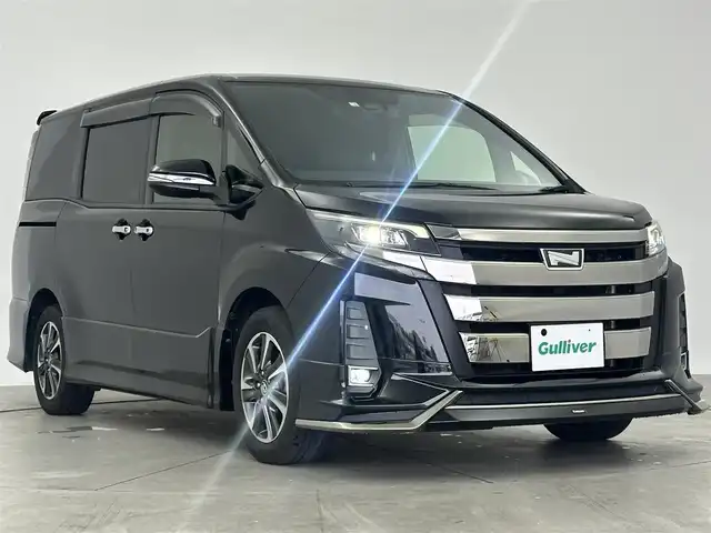 トヨタ ノア Si 大阪府 2018(平30)年 7.6万km ブラック 7人乗り/モデリスタエアロ/アルパイン7型ワイドSDナビ/フルセグTV/USBポート/バックカメラ/アルパイン後席フリップダウンモニター/ビルトインETC/ドライブレコーダー/ステアリングリモコン/MTモード/両側パワースライドドア/革調シートカバー/アイドリングストップ/トヨタセーフティセンス/　　・レーンアシスト/　　・クルーズコントロール/　　・車両&歩行者検知システム/オートハイビーム/HIDヘッドライト/フォグランプ/スマートキー