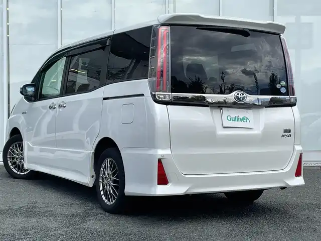 トヨタ ノア ハイブリッド Si ダブルバイビー 福岡県 2018(平30)年 8.9万km ホワイトパールクリスタルシャイン 純正9インチナビ/（AM/FM/SD/SDREC/BT/CD/DVD/フルセグ）/純正12.1インチフリップダウンモニター/クルーズコントロール/前後コーナーセンサー/レーンキープアシスト/プリクラッシュセーフティ/オートハイビーム/ETC/バックカメラ/前後ドライブレコーダー/両側パワースライドドア/純正16インチアルミホイール/純正フロアマット/純正ドアバイザー/ハーフレザーシート/D+N席シートヒーター/オートライト/LEDヘッドライト/フォグランプ/WAC/後席サンシェード/プッシュスタート/スマートキー/スペアキー/スタッドレスタイヤ4本付き/取扱説明書・保証書