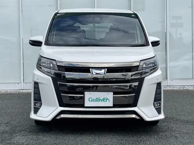 トヨタ ノア ハイブリッド Si ダブルバイビー 福岡県 2018(平30)年 8.9万km ホワイトパールクリスタルシャイン 純正9インチナビ/（AM/FM/SD/SDREC/BT/CD/DVD/フルセグ）/純正12.1インチフリップダウンモニター/クルーズコントロール/前後コーナーセンサー/レーンキープアシスト/プリクラッシュセーフティ/オートハイビーム/ETC/バックカメラ/前後ドライブレコーダー/両側パワースライドドア/純正16インチアルミホイール/純正フロアマット/純正ドアバイザー/ハーフレザーシート/D+N席シートヒーター/オートライト/LEDヘッドライト/フォグランプ/WAC/後席サンシェード/プッシュスタート/スマートキー/スペアキー/スタッドレスタイヤ4本付き/取扱説明書・保証書