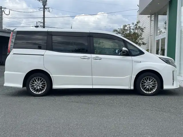 トヨタ ノア ハイブリッド Si ダブルバイビー 福岡県 2018(平30)年 8.9万km ホワイトパールクリスタルシャイン 純正9インチナビ/（AM/FM/SD/SDREC/BT/CD/DVD/フルセグ）/純正12.1インチフリップダウンモニター/クルーズコントロール/前後コーナーセンサー/レーンキープアシスト/プリクラッシュセーフティ/オートハイビーム/ETC/バックカメラ/前後ドライブレコーダー/両側パワースライドドア/純正16インチアルミホイール/純正フロアマット/純正ドアバイザー/ハーフレザーシート/D+N席シートヒーター/オートライト/LEDヘッドライト/フォグランプ/WAC/後席サンシェード/プッシュスタート/スマートキー/スペアキー/スタッドレスタイヤ4本付き/取扱説明書・保証書