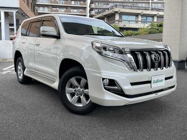 トヨタ ランドクルーザー プラド TX Lパッケージ 大阪府 2015(平27)年 8.2万km ホワイトパールクリスタルシャイン フロントモデリスタエアロ/社外マフラー/サンルーフ/純正ナビTV/バックカメラ/フロント、サイドカメラ/ベージュ革シート/前席シートヒーター/前席パワーシート/純正１７インチAW/LEDヘッドライト/クリアランスソナー/ダウンヒルアシスト/センターデフロック/クルーズコントロール/ドライブレコーダー/ビルトインETC/プッシュスタート/スマートキー/スペアキー/保証書付整備手帳/取扱説明書