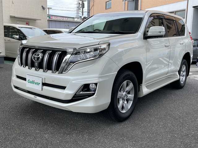 トヨタ ランドクルーザー プラド TX Lパッケージ 大阪府 2015(平27)年 8.2万km ホワイトパールクリスタルシャイン フロントモデリスタエアロ/社外マフラー/サンルーフ/純正ナビTV/バックカメラ/フロント、サイドカメラ/ベージュ革シート/前席シートヒーター/前席パワーシート/純正１７インチAW/LEDヘッドライト/クリアランスソナー/ダウンヒルアシスト/センターデフロック/クルーズコントロール/ドライブレコーダー/ビルトインETC/プッシュスタート/スマートキー/スペアキー/保証書付整備手帳/取扱説明書