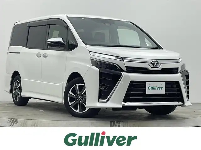 トヨタ ヴォクシー ZS 煌Ⅲ 宮城県 2020(令2)年 3.5万km ホワイトパールクリスタルシャイン ７人乗り/ワンオーナー/黒ハーフレザーシート/ドアエッジモール(両側フロントドア)/シートバックテーブル/サイドテーブル/純正12.1インチフリップダウンモニター【V12T-R68C】/純正10インチSDナビ【NSZN-Z68T】/(AM/FM/Bluetooth/CD/DVD/フルセグTV)/バックカメラ/ビルトインETC/Toyota Safety Sense/・LDA(レーンディパーチャーアラート)/・オートマチックハイビーム/・先行車発進告知機能/・PCS(プリクラッシュセーフティ)/クルーズコントロール/アイドリングストップ/両側パワースライドドア/オートライト/クリアランスソナー/コーナーセンサー/フロントフォグランプ/盗難防止装置/横滑り防止機能/電格ウィンカーミラー/プッシュスタート/フロアマット/純正１６インチアルミホイール/ステアリングスイッチ/USB充電ソケット×２/前後ドライブレコーダーYupiteru【SN-TW78d】/後席用サンシェード/スペアキー×１/ドアバイザー/ドラレコ取扱説明書/取扱説明書/保証書
