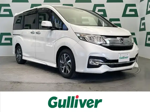 ホンダ ステップワゴン スパーダ 鹿児島県 2015(平27)年 6.6万km ホワイトオーキッドパール 禁煙車/社外ナビ【AVIC-RZ09】/（Bluetooth/フルセグTV）/社外フリップダウンモニター/バックモニター/ホンダセンシング/・衝突軽減ブレーキ/・アダプティブクルーズコントロール/・車線維持支援システム/・路外逸脱抑制機能/・誤発信抑制機能/・先行車発進お知らせ機能/・標識認識機能/両側パワースライドドア/前後ドライブレコーダー
