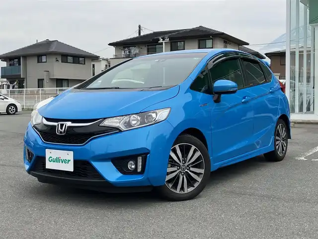 ホンダ フィット ハイブリット Sパッケージ 静岡県 2016(平28)年 7万km ビビットスカイブルーP エンジンスタートボタン/スマートキー/アイドリングストップ/パワーステアリング/パワーウィンドウ/MTモード付AT/寒冷地仕様/オートエアコン/クルーズコントロール/USB入力端子/ETC/純正ナビ（CD.DVD.BT.ワンセグ）/バックカメラ/ドライブレコーダー/純正フロアマット/純正アルミホイール/ABS/横滑り防止装置/オートライト/LEDヘッドライト/Wプラスサイドエアバック/カーテンエアバック/衝突軽減システム/ナビ装着用スペシャルパッケージ/Sパッケージ/コンフォートビューパッケージ/あんしんパッケージ/電動格納ミラー＋プライバシーガラス/オートリトラミラー/スーパーUVカットフロントドアガラス/IRカットガラス/プラズマクラスター/セキュリティアラーム/ラゲッジルームランプ/アームレスト付センターコンソールボックス