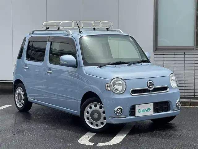ダイハツ ミラ ココア プラスX 三重県 2012(平24)年 9.6万km ミストブルーマイカメタリック ルーフキャリア/バックカメラ/純正ナビ(Bluetooth/DVD/CD/地デジTV/SD/iPod/USB/VTR/AM/FM)/電動格納ミラー/純正フロアマット/照明付バニティミラー/メッキ加飾付フロントフォグランプ/シルバールーフレール/トップシェイドフロントウィンドウ/「Cocoa」エンブレム付イエローベージュスエード調ファブリックシート/シートバックティッシュポケット(助手席)/分割可倒式シート(リア)/フロアイルミネーション(運転席)/グローブボックスランプ