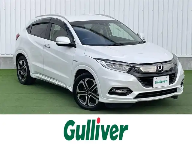 ホンダ ヴェゼル ハイブリッド Z ホンダセンシング 香川県 2018(平30)年 5.2万km プラチナホワイトパール 純正8インチメモリナビ/→フルセグ/CD/DVD/Bluetooth/HDMI/USB/バックカメラ/Honda SENSING/・CMBS(衝突被害軽減ブレーキ)/・ACC（アダプティブクルーズコントロール）/・LKAS（車線維持支援システム）/・路外逸脱抑制機能/・先行車発進お知らせ機能/・誤発進抑制機能/・歩行者事故低減ステアリング/・標識認識機能/・オートハイビーム/ハーフレザーシート/前席シートヒーター/LEDオートライト/純正革巻きステアリング/ステアリングスイッチ/パドルシフト/電子パーキングブレーキ/オートブレーキホールド/純正17インチアルミ/純正フロアマット/ビルトインETC/純正前方ドライブレコーダー/アイドリングストップ/プッシュスタート/キーレス/スタッドレスタイヤ積込