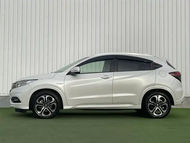 ホンダ ヴェゼル ハイブリッド Z ホンダセンシング 香川県 2018(平30)年 5.2万km プラチナホワイトパール 純正8インチメモリナビ/→フルセグ/CD/DVD/Bluetooth/HDMI/USB/バックカメラ/Honda SENSING/・CMBS(衝突被害軽減ブレーキ)/・ACC（アダプティブクルーズコントロール）/・LKAS（車線維持支援システム）/・路外逸脱抑制機能/・先行車発進お知らせ機能/・誤発進抑制機能/・歩行者事故低減ステアリング/・標識認識機能/・オートハイビーム/ハーフレザーシート/前席シートヒーター/LEDオートライト/純正革巻きステアリング/ステアリングスイッチ/パドルシフト/電子パーキングブレーキ/オートブレーキホールド/純正17インチアルミ/純正フロアマット/ビルトインETC/純正前方ドライブレコーダー/アイドリングストップ/プッシュスタート/キーレス/スタッドレスタイヤ積込