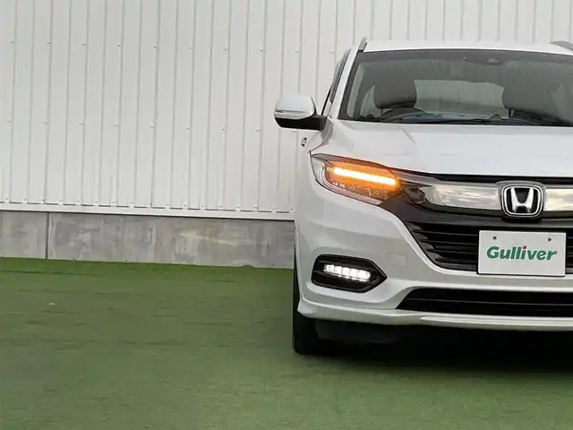 ホンダ ヴェゼル ハイブリッド Z ホンダセンシング 香川県 2018(平30)年 5.2万km プラチナホワイトパール 純正8インチメモリナビ/→フルセグ/CD/DVD/Bluetooth/HDMI/USB/バックカメラ/Honda SENSING/・CMBS(衝突被害軽減ブレーキ)/・ACC（アダプティブクルーズコントロール）/・LKAS（車線維持支援システム）/・路外逸脱抑制機能/・先行車発進お知らせ機能/・誤発進抑制機能/・歩行者事故低減ステアリング/・標識認識機能/・オートハイビーム/ハーフレザーシート/前席シートヒーター/LEDオートライト/純正革巻きステアリング/ステアリングスイッチ/パドルシフト/電子パーキングブレーキ/オートブレーキホールド/純正17インチアルミ/純正フロアマット/ビルトインETC/純正前方ドライブレコーダー/アイドリングストップ/プッシュスタート/キーレス/スタッドレスタイヤ積込