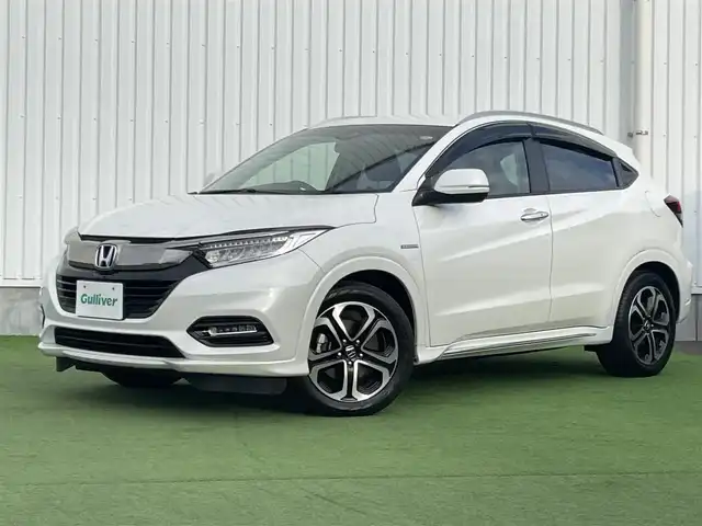 ホンダ ヴェゼル ハイブリッド Z ホンダセンシング 香川県 2018(平30)年 5.2万km プラチナホワイトパール 純正8インチメモリナビ/→フルセグ/CD/DVD/Bluetooth/HDMI/USB/バックカメラ/Honda SENSING/・CMBS(衝突被害軽減ブレーキ)/・ACC（アダプティブクルーズコントロール）/・LKAS（車線維持支援システム）/・路外逸脱抑制機能/・先行車発進お知らせ機能/・誤発進抑制機能/・歩行者事故低減ステアリング/・標識認識機能/・オートハイビーム/ハーフレザーシート/前席シートヒーター/LEDオートライト/純正革巻きステアリング/ステアリングスイッチ/パドルシフト/電子パーキングブレーキ/オートブレーキホールド/純正17インチアルミ/純正フロアマット/ビルトインETC/純正前方ドライブレコーダー/アイドリングストップ/プッシュスタート/キーレス/スタッドレスタイヤ積込