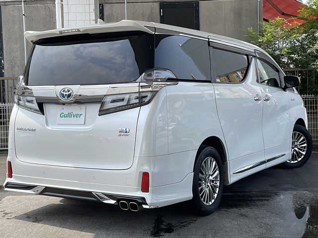 トヨタ ヴェルファイア ハイブリット ZR Gエディション 京都府 2018(平30)年 9万km ホワイトパールクリスタルシャイン ＪＢＬメーカーナビ/AM/FM/AUX/HDMI/USB/Bluetooth/フルセグＴＶ/（キャンセラー付き）/全方位モニター/サンルーフ/純正フリップダウンモニター/モデリスタフルエアロ/　（マフラーカッター）/三眼ＬＥＤヘッドライト/レーダークルーズコントロール/両側パワースライドドア/電動リアゲート/トヨタセーフティーセンス/LEDシグネチャーイルミブレード/デジタルミラー/ブラインドスポットモニター/メモリー付きパワーシート/デュアルエアコン/レザーシート/前席ベンチレーション/前席シートヒーター/ステアリングヒーター/ビルトイン2.0ETC/前方ドライブレコーダー/盗難防止装置/（社外セキュリティ）/100V電源/プッシュスタート/スマートキー/3列シート/オットマン/ウォークスルー/レーンキープアシスト/横滑り防止装置/前後コーナーセンサー/オートマチックハイビーム/AFS/（アダクティブフロントライティングシステム）/ダブルエアバッグ+サイドエアバッグ/フォグライト