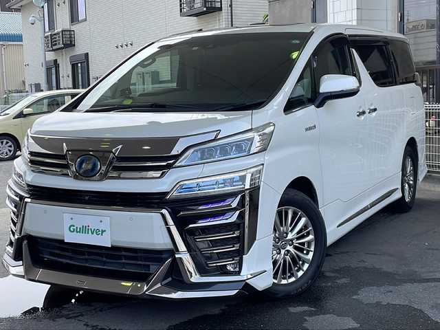 トヨタ ヴェルファイア ハイブリット ZR Gエディション 京都府 2018(平30)年 9万km ホワイトパールクリスタルシャイン ＪＢＬメーカーナビ/AM/FM/AUX/HDMI/USB/Bluetooth/フルセグＴＶ/（キャンセラー付き）/全方位モニター/サンルーフ/純正フリップダウンモニター/モデリスタフルエアロ/　（マフラーカッター）/三眼ＬＥＤヘッドライト/レーダークルーズコントロール/両側パワースライドドア/電動リアゲート/トヨタセーフティーセンス/LEDシグネチャーイルミブレード/デジタルミラー/ブラインドスポットモニター/メモリー付きパワーシート/デュアルエアコン/レザーシート/前席ベンチレーション/前席シートヒーター/ステアリングヒーター/ビルトイン2.0ETC/前方ドライブレコーダー/盗難防止装置/（社外セキュリティ）/100V電源/プッシュスタート/スマートキー/3列シート/オットマン/ウォークスルー/レーンキープアシスト/横滑り防止装置/前後コーナーセンサー/オートマチックハイビーム/AFS/（アダクティブフロントライティングシステム）/ダブルエアバッグ+サイドエアバッグ/フォグライト