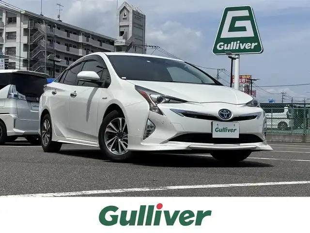 トヨタ プリウス A 大分県 2018(平30)年 8.3万km ホワイトパールクリスタルシャイン 純正SDナビ/・AM/FM/フルセグ/CD/DVD/Bluetooth/SD/トヨタセーフティセンス/・レーダークルーズコントロール/・レーンディパーチャーアラート/・ブラインドスポットモニター/・プリクラッシュセーフティ/・RCTA/・パーキングアシスト/・ヘッドアップディスプレイ/・クリアランスソナー/・オートハイビーム/バックカメラ/ビルトインETC/モデリスタアルミホイール/社外エアロ（フロント/サイド/リア）/オートライト/LEDヘッドライト/革巻きステアリング/ステアリングスイッチ/プッシュスタート/スマートキー×2/純正フロアマット