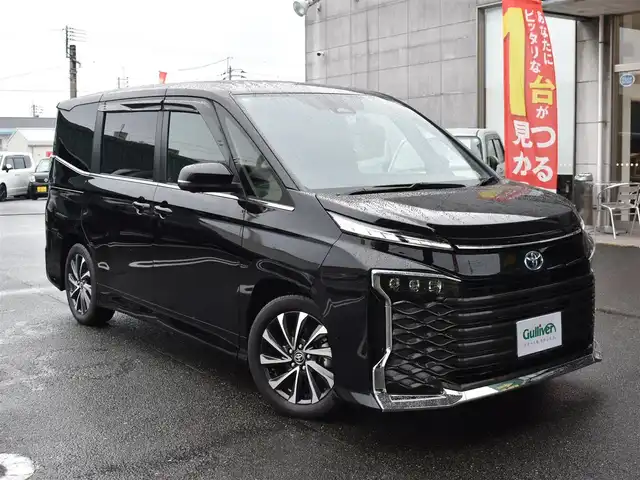 トヨタ ヴォクシー ハイブリッド S－Z 福岡県 2025(令7)年 0.2万km アティチュードブラックマイカ ワンオーナー/トヨタセーフティセンス/快適利便パッケージ(High)/純正OP10.5インチディスプレイオーディオ/フルセグ/CD/DVD/BT/HDMI/パノラミックビューモニター/純正OP13．2型後席ディスプレイ/純正OP3眼LEDヘッドライト/純正OPブラインドスポットモニター/純正OPアドバンストパーク/純正OPパーキングブレーキサポート/純正OPカラーヘッドアップディスプレイ/純正OPデジタルインナーミラー/純正ラグジュアリーフロアマット/純正GRスポーツサイドバイザー/TZ前後ドライブレコーダー/両側パワースライドドア/リア5面スモークフィルム/ビルトインETC2.0/新車時保証書/取扱説明書