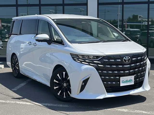 トヨタ アルファードハイブリット エグゼクティブ ラウンジ 道東・釧路十勝 2023(令5)年 4.8万km ホワイトパールクリスタルシャイン ・T-Connect SD 10.5型ナビゲーションシステム/（AM・FM・フルセグ・DVD・ナビ・BT）/・全周囲カメラ　/・リヤシートエンターテインメントシステム/・純正14インチフリップダウンモニター/・JBLプレミアムサウンドシステム/・左右独立ムーンルーフ/・後席電動サンシェード/・レーダークルーズコントロール/・両側パワースライドドア/・純正ＥＴＣ２．０　/・12.3インチTFTカラーメーター/・マルチインフォメーションディスプレイ/・リヤマルチオペレーションパネル（脱着式）/・セカンドシートマッサージ機能/・本革巻き3本スポークステアリングホイール/（ステアリングヒーター付）/・AC100V電源（１５００W）/・おもてなし集中スイッチ/・ドライブレコーダー前後　/・パワーバックドア/・電動格納サードシート/・純正フロアマット/・本革シート/・シートヒーター全席/・エアシート全席/・1９インチ純正アルミホイール/・コーナーセンサー前後/・レーンキープアシスト/・オートマチックハイビーム/・デジタルインナーミラー