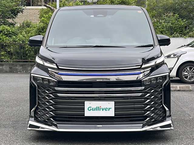トヨタ ヴォクシー ハイブリッド S－Z 埼玉県 2023(令5)年 2.2万km アティチュードブラックマイカ 登録時21767km/ワンオーナー/モデリスタエアロ/両側パワースライドドア/パワーバックドア/ディスプレイオーディオ【コネクティッドナビ対応】Plus/   10.5インチ　車載ナビ/AM/FM/CD/DVD/BT//   USB/HDMI/フルセグTV/バックカメラ/全方位カメラ/純正フリップダウンモニター/ハーフレザーシート/シートヒーター（D+N席）/トヨタセーフティセンス/　プリクラッシュセーフティ/レーントレーシングアシスト/　レーンディパーチャーアラート/レーダークルーズコントロール/　アダプティブハイビームシステム/ロードサインアシスト/　ドライバー異常時対応システム/発進遅れ告知機能/　プロアクティブドライビングアシスト/緊急時操舵支援/　フロントクロストラフィックアラート/レーンチェンジアシスト/アドバンスパーク/アイドリングストップ/ドライブレコーダー/ETC2.0/デジタルインナーミラー/電動格納ミラー/ウィンカーミラー/プッシュスタート/スマートキーx2/純正LEDライト/オートライト/フォグランプ/社外19インチAW/ローダウン/ドアバイザー/純正フロアマット/保証書/取扱説明書