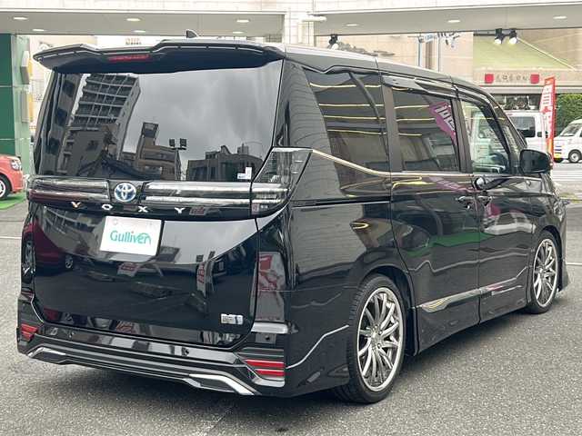 トヨタ ヴォクシー ハイブリッド S－Z 埼玉県 2023(令5)年 2.2万km アティチュードブラックマイカ 登録時21767km/ワンオーナー/モデリスタエアロ/両側パワースライドドア/パワーバックドア/ディスプレイオーディオ【コネクティッドナビ対応】Plus/   10.5インチ　車載ナビ/AM/FM/CD/DVD/BT//   USB/HDMI/フルセグTV/バックカメラ/全方位カメラ/純正フリップダウンモニター/ハーフレザーシート/シートヒーター（D+N席）/トヨタセーフティセンス/　プリクラッシュセーフティ/レーントレーシングアシスト/　レーンディパーチャーアラート/レーダークルーズコントロール/　アダプティブハイビームシステム/ロードサインアシスト/　ドライバー異常時対応システム/発進遅れ告知機能/　プロアクティブドライビングアシスト/緊急時操舵支援/　フロントクロストラフィックアラート/レーンチェンジアシスト/アドバンスパーク/アイドリングストップ/ドライブレコーダー/ETC2.0/デジタルインナーミラー/電動格納ミラー/ウィンカーミラー/プッシュスタート/スマートキーx2/純正LEDライト/オートライト/フォグランプ/社外19インチAW/ローダウン/ドアバイザー/純正フロアマット/保証書/取扱説明書