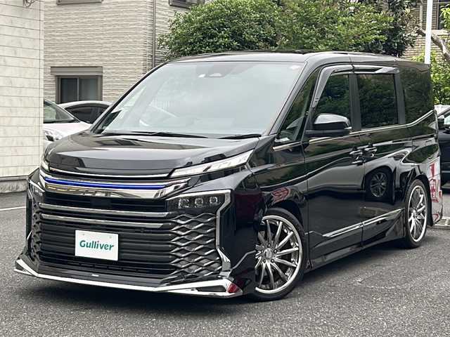 トヨタ ヴォクシー ハイブリッド S－Z 埼玉県 2023(令5)年 2.2万km アティチュードブラックマイカ 登録時21767km/ワンオーナー/モデリスタエアロ/両側パワースライドドア/パワーバックドア/ディスプレイオーディオ【コネクティッドナビ対応】Plus/   10.5インチ　車載ナビ/AM/FM/CD/DVD/BT//   USB/HDMI/フルセグTV/バックカメラ/全方位カメラ/純正フリップダウンモニター/ハーフレザーシート/シートヒーター（D+N席）/トヨタセーフティセンス/　プリクラッシュセーフティ/レーントレーシングアシスト/　レーンディパーチャーアラート/レーダークルーズコントロール/　アダプティブハイビームシステム/ロードサインアシスト/　ドライバー異常時対応システム/発進遅れ告知機能/　プロアクティブドライビングアシスト/緊急時操舵支援/　フロントクロストラフィックアラート/レーンチェンジアシスト/アドバンスパーク/アイドリングストップ/ドライブレコーダー/ETC2.0/デジタルインナーミラー/電動格納ミラー/ウィンカーミラー/プッシュスタート/スマートキーx2/純正LEDライト/オートライト/フォグランプ/社外19インチAW/ローダウン/ドアバイザー/純正フロアマット/保証書/取扱説明書