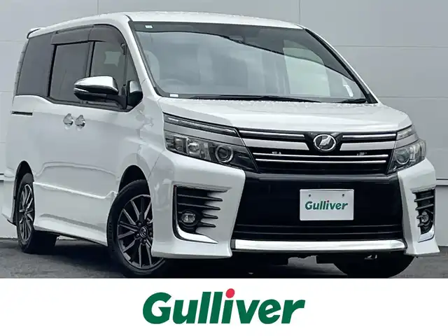 トヨタ ヴォクシー ZS 煌Ⅱ 佐賀県 2016(平28)年 5.8万km ホワイトパールクリスタルシャイン トヨタセーフティセンスC/・プリクラッシュセーフティ/・オートマチックハイビーム/・レーンディパーチャーアラート/純正SDナビ　/・バックカメラ　/・フルセグＴＶ（走行視聴可）/・BT/CD/DVD　/純正後席モニター　/両側パワースライドドア　/純正１５インチＡＷ　/ＬＥＤヘッドライト　/フォグランプ　/ETC2.0 /革調シートカバー　/スペアキー×1/取扱説明書/保証書/社外マフラーカッター