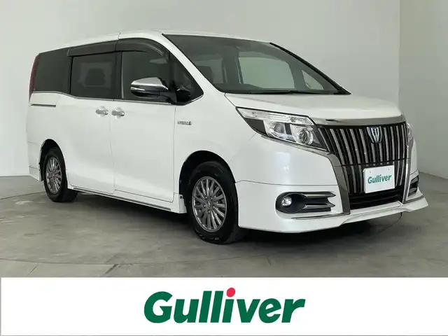 トヨタ エスクァイア ハイブリッド Gi ブラックテーラード 奈良県 2016(平28)年 8.3万km ホワイトパールクリスタルシャイン 純正9インチナビ/純正フリップダウンモニター/バックカメラ/両側パワースライドドア/衝突被害軽減ブレーキ/クルーズコントロール/横滑り防止装置/合皮シート/前席シートヒーター/ビルトインETC/純正AW15インチ/純正フロアマット/LEDオートライト/ステアリングスイッチ/スマートキー/プッシュスタート/デュアルエアコン/オートライト/ウォークスルー/3列シート