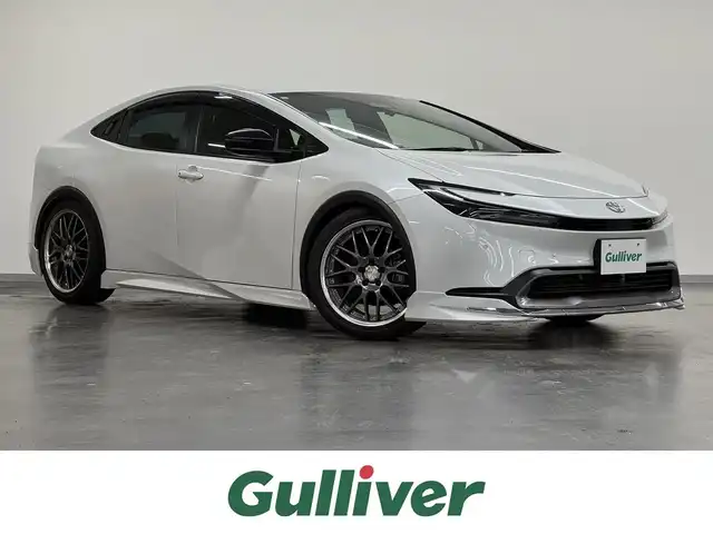 トヨタ プリウス G 三重県 2023(令5)年 1.2万km プラチナホワイトパールマイカ モデリスタエアロ（F/S/R）/WORK 19インチAW/　『LANVEC（ランベック）LM-1』/純正 8インチディスプレイオーディオ＆ナビ/（FM/AM/TV/Bluetooth/USB/iPod//CarPlay/AndroidAuto/Miracast）/バックガイドモニター/RSR ダウンサス/ドライブレコーダー 全方位/ビルトイン ETC2.0/Toyota Safety Sense/●プリクラッシュセーフティ/●レーントレーシングアシスト＋レーンディパーチャーアラート/●レーダークルコン（全車速追従機能付）/●オートハイビーム/●ロードサインアシスト/●ドライバー異常時対応システム/●プロアクティブドライビングアシスト/●発進遅れ告知機能［TMN］/・ブラインドスポットモニター/・あんしん降車アシスト［SEA］/・後方車両接近告知　など/装備/・AC100Vアクセサリーコンセント（1500W）/・シートヒーター（D/N）/・LEDオートヘッドランプ/・オートエアコン/・電子パーキングブレーキ＆ブレーキホールド/・ステアリングスイッチ/・プッシュスタート/・保/取/・スマートキーx2/禁煙車