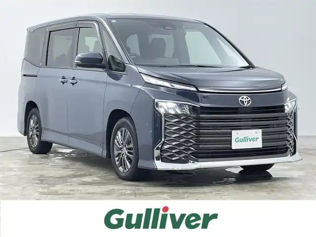 トヨタ ヴォクシー S－G 千葉県 2024(令6)年 1.7万km マッシブグレー 禁煙車/ワンオーナー/両側電動ドア/トヨタセーフティセンス/・プリクラッシュセーフティ/・プリクラッシュセーフティブレーキ/・クリアランスソナー/・レーダークルーズコントロール/・レーンキープアシスト/・レーンディパーチャーアラート/13.2型有機ELフリップダウンモニター/純正10.5インチディスプレイオーディオ/・CD/DVD/USB/Bluetooth/フルセグTV/・ビルトインETC2.0 /・バックカメラ/革巻きステアリング/・ステアリングスイッチ/MT付きAT/電子パーキング/・ブレーキホールド/左右独立エアコン/純正フロアマット/純正ドアバイザー/純正16インチAW/オートライト/・オートマチックハイビーム/・LEDヘッドライト/・LEDフォグランプ/・ヘッドライトレベライザー