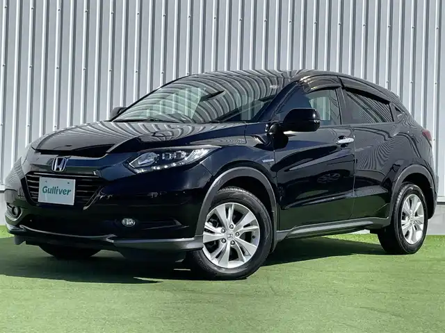 ホンダ ヴェゼル ハイブリッド X 香川県 2014(平26)年 2.1万km クリスタルブラックパール 登録時走行距離：20835km/純正7インチナビ/→CD再生/→Bluetooth/クルーズコントロール/革巻きステアリング/LEDヘッドライト/オートライト/純正16インチアルミホイール/プッシュスタート/純正フロアマット/電動格納ウィンカーミラー/バイザー