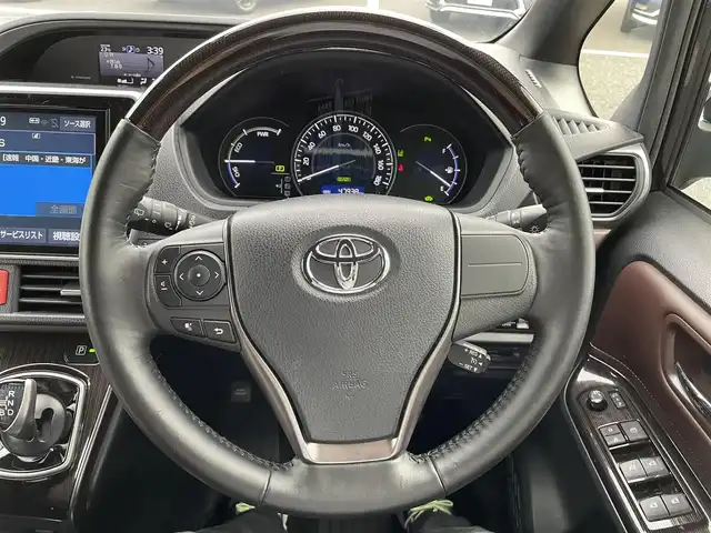 トヨタ エスクァイア ハイブリッド Gi プレミアムパッケージ 千葉県 2019(平31)年 4.8万km スパークリングブラックパールクリスタルシャイン 純正10インチナビ/(フルセグTV/BT/CD/DVD/FM/AM)/バックカメラ/衝突被害軽減システム/車線逸脱警報/クルーズコントロール/ハーフレザーシート/両側パワースライドドア/横滑り防止装置/ビルトインETC/アイドリングストップ/LEDヘッドライト/フォグランプ/オートライト/ウィンカーミラー/電動格納ミラー/純正15インチAW/シートヒーター/シートリフター/ステアリングヒーター/プッシュスタート/スマートキー/フロアマット/ドアバイザー/取扱説明書/保証書