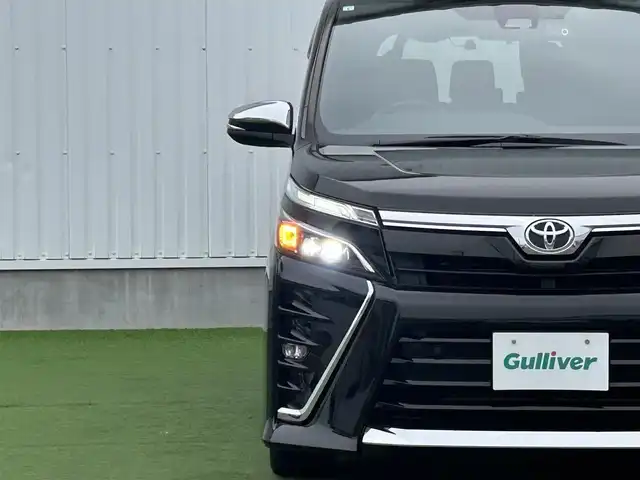 トヨタ ヴォクシー ZS 煌Ⅲ 香川県 2021(令3)年 6.7万km イナズマスパーキングブラックガラスフレーク 登録時走行距離：66749km/トヨタセーフティーセンス/純正10インチナビ/→フルセグTV/→Bluetooth/バックカメラ/ETC/ドライブレコーダー/クルーズコントロール/レーンキープアシスト/プッシュスタート/両側パワースライドドア/LEDヘッドライト/純正16インチアルミホイール/革巻きステアリング/ステアリモコン/ハーフレザーシート/電動格納ウィンカーミラー/スマートキー