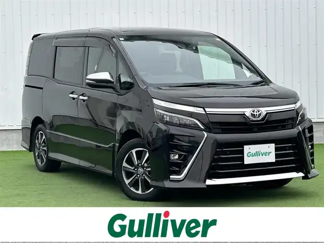 トヨタ ヴォクシー ZS 煌Ⅲ 香川県 2021(令3)年 6.7万km イナズマスパーキングブラックガラスフレーク 登録時走行距離：66749km/トヨタセーフティーセンス/純正10インチナビ/→フルセグTV/→Bluetooth/バックカメラ/ETC/ドライブレコーダー/クルーズコントロール/レーンキープアシスト/プッシュスタート/両側パワースライドドア/LEDヘッドライト/純正16インチアルミホイール/革巻きステアリング/ステアリモコン/ハーフレザーシート/電動格納ウィンカーミラー/スマートキー