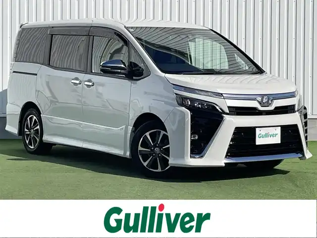 トヨタ ヴォクシー ZS 煌Ⅱ 香川県 2019(令1)年 7.4万km ホワイトパールクリスタルシャイン 純正10型SDナビゲーショ/→フルセグ/→CD/DVD/12.1型フリップダウンモニター/両側パワースライドドア/バックカメラ/クリアランスソナー/トヨタセーフティセンス/→プリクラッシュセーフティ/→レーンディパーチャーアラート/→レーントレーシングアシスト/→レーダークルーズコントロール/→オートマチックハイビーム/ビルトインETC/ドライブレコーダー（前後）/ステアリングスイッチ/三眼LEDヘッドライト/オートヘッドライト/電動格納ミラー（ウィンカー付）/パーソナルテーブル/後席サンシェード/スマートキー