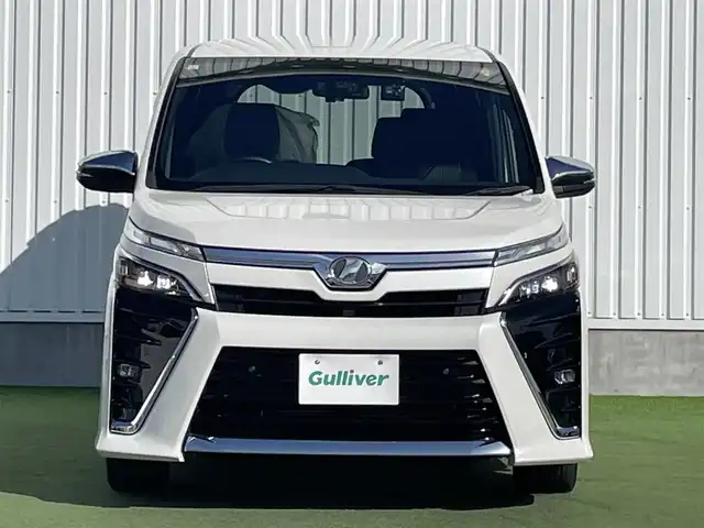 トヨタ ヴォクシー ZS 煌Ⅱ 香川県 2019(令1)年 7.4万km ホワイトパールクリスタルシャイン 純正10型SDナビゲーショ/→フルセグ/→CD/DVD/12.1型フリップダウンモニター/両側パワースライドドア/バックカメラ/クリアランスソナー/トヨタセーフティセンス/→プリクラッシュセーフティ/→レーンディパーチャーアラート/→レーントレーシングアシスト/→レーダークルーズコントロール/→オートマチックハイビーム/ビルトインETC/ドライブレコーダー（前後）/ステアリングスイッチ/三眼LEDヘッドライト/オートヘッドライト/電動格納ミラー（ウィンカー付）/パーソナルテーブル/後席サンシェード/スマートキー