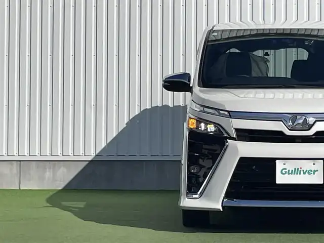 トヨタ ヴォクシー ZS 煌Ⅱ 香川県 2019(令1)年 7.4万km ホワイトパールクリスタルシャイン 純正10型SDナビゲーショ/→フルセグ/→CD/DVD/12.1型フリップダウンモニター/両側パワースライドドア/バックカメラ/クリアランスソナー/トヨタセーフティセンス/→プリクラッシュセーフティ/→レーンディパーチャーアラート/→レーントレーシングアシスト/→レーダークルーズコントロール/→オートマチックハイビーム/ビルトインETC/ドライブレコーダー（前後）/ステアリングスイッチ/三眼LEDヘッドライト/オートヘッドライト/電動格納ミラー（ウィンカー付）/パーソナルテーブル/後席サンシェード/スマートキー