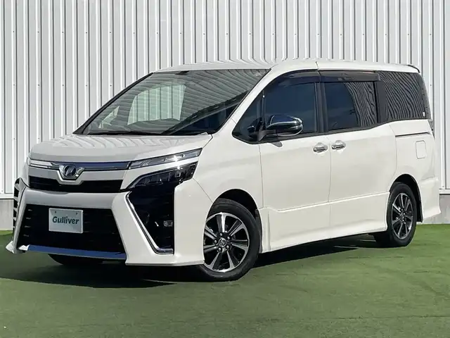 トヨタ ヴォクシー ZS 煌Ⅱ 香川県 2019(令1)年 7.4万km ホワイトパールクリスタルシャイン 純正10型SDナビゲーショ/→フルセグ/→CD/DVD/12.1型フリップダウンモニター/両側パワースライドドア/バックカメラ/クリアランスソナー/トヨタセーフティセンス/→プリクラッシュセーフティ/→レーンディパーチャーアラート/→レーントレーシングアシスト/→レーダークルーズコントロール/→オートマチックハイビーム/ビルトインETC/ドライブレコーダー（前後）/ステアリングスイッチ/三眼LEDヘッドライト/オートヘッドライト/電動格納ミラー（ウィンカー付）/パーソナルテーブル/後席サンシェード/スマートキー