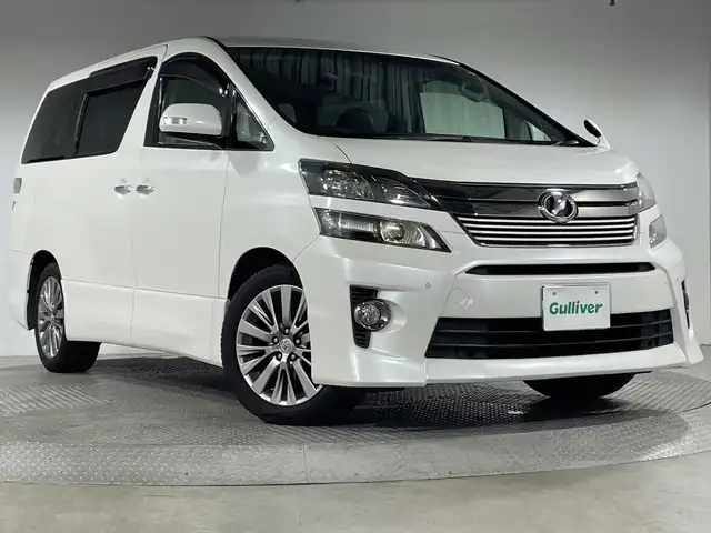 トヨタ ヴェルファイア 2．4Z ゴールデンアイズⅡ 神奈川県 2014(平26)年 7.3万km ホワイトパールクリスタルシャイン 社外10型SDナビゲーション【EX1000】/・BT/フルセグTV/CD/DVD/SD/バックカメラ/フリップダウンモニター/両側電動スライドドア/パワーバックドア/ハーフレザーシート/ウッドコンビステアリング/ステアリングスイッチ/クルーズコントロール/Autoライト/ECOモード/MTモード/HIDヘッドライト/フォグランプ/自動防眩ミラー/電動格納ミラー/ウィンカーミラー/コーナーセンサー/シートリフター/純正フロアマット/純正ドアバイザー/純正18インチアルミホイール