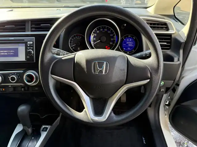 ホンダ フィット 13G Fパッケージ 静岡県 2015(平27)年 6万km タフタホワイト ワンオーナー/　・新車時保証書有り/走行距離：59/302Km(登録時)/車検：令和8年9月6日　迄/アイドリングストップ/純正ディスプレイオーディオ/バックカメラ/スマートキー×2/プッシュスタート/ウインカードアミラー/純正ドアバイザー/純正フロアマット/Wエアバック＋ABS/取説有り