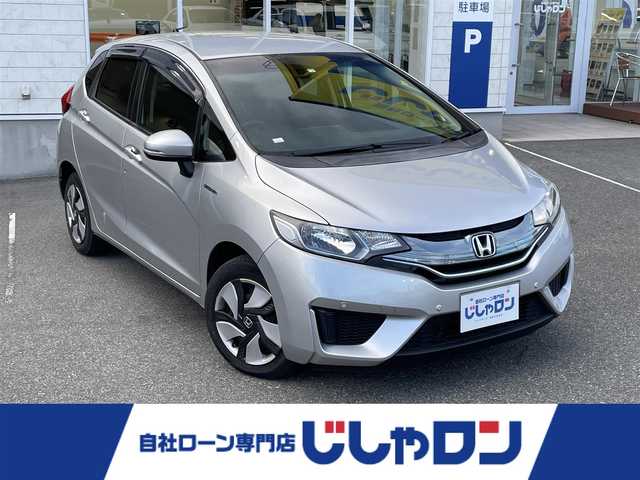 ホンダ フィット ハイブリット Fパッケージ 山梨県 2015(平27)年 8万km アラバスターシルバーメタリック (株)IDOMが運営する【じしゃロン甲府店】の自社ローン専用車両になります。/こちらは現金またはオートローンご利用時の価格です。自社ローンご希望の方は別途その旨お申付け下さい/スマートキー/社外ナビ・フルセグＴＶ/ＳＤ・ＢＴ/Ｂカメラ/保証書・取説書
