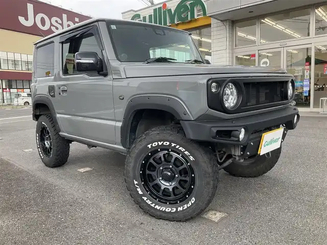 スズキ ジムニー XC 滋賀県 2021(令3)年 4.3万km ミディアムグレー 純正9インチナビゲーション/・Bluetooth・フルセグTV/FRPボンネット/FRバンパー（ショウワガレージ）/スキッドプレート（ショウワガレージ）/マフラー（ショウワガレージ）/テールランプ（ショウワガレージ）/フロントグリル（ショウワガレージ）/エアクリーナー（GReddy)/ブローオフバルブ（GReddy)/インタークーラ（GReddy)/シャックアブソーバー14段階調節式（タニグチ）/サスペンションスプリング/ラテラルロッド/オイルキャッチタンク/HKSブーストコントローラー（powerEditor)/社外フロントカメラ/ブーストメーター（Pivot）/ステアリング（ナルディー）/アルパインデジタルインナーミラー/・前後ドライブレコーダー付き/社外16AW（Toyoオープンカントリー）/ビルトインETC/保証書・取説・スペアキー/