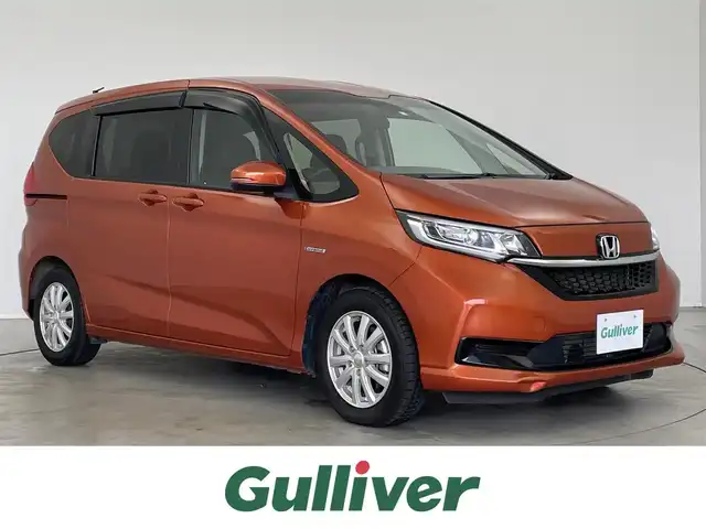 ホンダ フリード ハイブリット G ホンダセンシング 埼玉県 2020(令2)年 2.7万km プレミアムクリスタルオレンジM センシング/・衝突軽減ブレーキ（CMBS）/・誤発進抑制機能/・後方誤発進抑制機能/・歩行者事故提言ステアリング/・路外逸脱抑制機能/・先行車発進お知らせ機能/・標識認識機能/・アクティブクルーズコントロール/・車線維持支援システム/純正ナビ（VXM-204VFI)/バックカメラ/プッシュスタート/純正フロアマット/両側パワースライドドア/純正ETC2.0/シートヒーター（運転席＆助手席）/フロントデアイサー/LEDヘッドライト