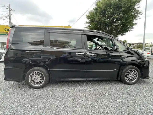 トヨタ ノア ハイブリッド Si ダブルバイビー 埼玉県 2017(平29)年 4.1万km ブラック ワンオーナー/シートヒーター/純正メモリーナビ＆ワンセグＴＶ/（ＤＶＤ＆ＣＤ＆ＢＴ）/フリップダウンモニター/バッックカメラ/ビルトインＥＴＣ（２.０）/純正ドライブレコーダー/トヨタセーフティーセンス/クルーズコントロール/革巻きステアリング/ステアリングリモコン/両側パワースライドドア/純正エアロ/純正１６inアルミホイール/オートハイビーム/オートライト/ＬＥＤライト/フォグランプ/ウィンカーミラー/オート電動格納ミラー/スマートキー/プッシュスタート/Ｗ＆サイド＆カーテンエアバッグ/横滑り防止装置/ＡＢＳ/ドアバイザー/フロアマット/新車保証書/取扱説明書/ナビ取扱説明書/スマートスペアキー有