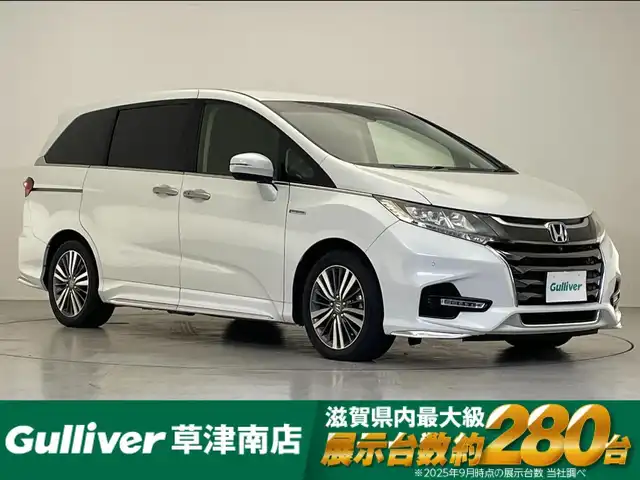 ホンダ オデッセイ ハイブリッド アブソルート・EXホンダセンジング 滋賀県 2018(平30)年 6.3万km プラチナホワイトパール 純正9インチナビ/【Bluetooth/USB/CD/DVD/フルセグTV/HDMI】/ハーフレザーシート/全方位カメラ/両側パワースライドドア/ホンダセンシング/・衝突軽減ブレーキ/・誤発進抑制機能/・歩行者事故低減ステアリング/・路外逸脱抑制機能/・渋滞追従機能付アダプティブクルーズコントロール/・LKAS〈車線維持支援システム〉/・先行車発進お知らせ機能/・標識認識機能/ブラインドスポットインフォメーション/LEDヘッドライト/クリアランスソナー/前後ドライブレコーダー/ビルトインETC2.0/電動パーキングブレーキ/オートブレーキホールド/D/Nパワーシート/D/Nシートヒーター/2列目オットマン/プッシュスタート/スマートキー/ステアリングリモコン