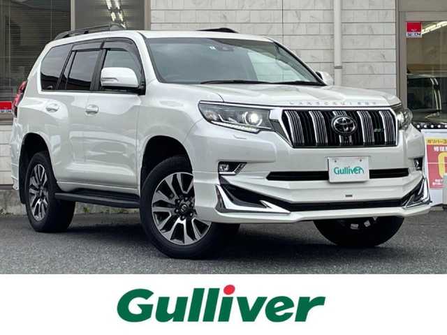 トヨタ ランドクルーザー プラド TX Lパッケージ 福岡県 2022(令4)年 2.6万km ホワイトパールクリスタルシャイン ワンオーナー/ルーフレール/ムーンルーフ/サイドステップ/全席黒レザーシート(合皮)/モデリスタエアロ【フロント・リア・マフラー】/TRDインナーステップガーニッシュ/インナードアハンドルカバー/純正９インチメモリナビ/【AM/FM/Bluetooth/USB/フルセグTV】/パノラミックビューモニター/ビルトインETC2.0/パワーシート(D/N席)/シートヒーター(D/N席)/エアーシート(D/N席)/トヨタセーフティセンス/・PCS(プリクラッシュセーフティ)/・LDA(レーンディパーチャーアラート)ヨーアシスト機能付き/・ふらつき警報機能/・車線逸脱警報機能/・車線逸脱抑制機能/・AHB(オートマチックハイビーム)/・RSA(ロードサインアシスト)/・レーダークルーズコントロール(全車速追従機能付き)/・先行車発進告知機能/BSM(ブラインドスポットモニター)/PKSB(パーキングサポートブレーキ)/ウィンドシールドデアイサー/社外デジタルインナーミラー型前後ドライブレコーダー(GPS付き)CELLSTAR【TZ-D203MW】/純正フロアマット/純正１５インチアルミホイール/スペアキー×１/ドアバイザー/取扱説明書/保証書