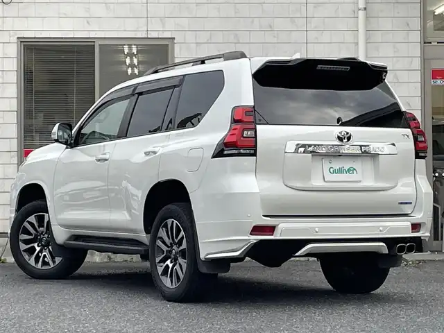 トヨタ ランドクルーザー プラド TX Lパッケージ 福岡県 2022(令4)年 2.6万km ホワイトパールクリスタルシャイン ワンオーナー/ルーフレール/ムーンルーフ/サイドステップ/全席黒レザーシート(合皮)/モデリスタエアロ【フロント・リア・マフラー】/TRDインナーステップガーニッシュ/インナードアハンドルカバー/純正９インチメモリナビ/【AM/FM/Bluetooth/USB/フルセグTV】/パノラミックビューモニター/ビルトインETC2.0/パワーシート(D/N席)/シートヒーター(D/N席)/エアーシート(D/N席)/トヨタセーフティセンス/・PCS(プリクラッシュセーフティ)/・LDA(レーンディパーチャーアラート)ヨーアシスト機能付き/・ふらつき警報機能/・車線逸脱警報機能/・車線逸脱抑制機能/・AHB(オートマチックハイビーム)/・RSA(ロードサインアシスト)/・レーダークルーズコントロール(全車速追従機能付き)/・先行車発進告知機能/BSM(ブラインドスポットモニター)/PKSB(パーキングサポートブレーキ)/ウィンドシールドデアイサー/社外デジタルインナーミラー型前後ドライブレコーダー(GPS付き)CELLSTAR【TZ-D203MW】/純正フロアマット/純正１５インチアルミホイール/スペアキー×１/ドアバイザー/取扱説明書/保証書