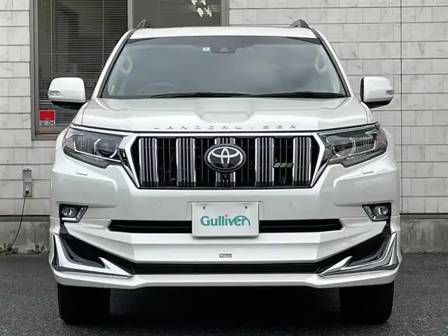 トヨタ ランドクルーザー プラド TX Lパッケージ 福岡県 2022(令4)年 2.6万km ホワイトパールクリスタルシャイン ワンオーナー/ルーフレール/ムーンルーフ/サイドステップ/全席黒レザーシート(合皮)/モデリスタエアロ【フロント・リア・マフラー】/TRDインナーステップガーニッシュ/インナードアハンドルカバー/純正９インチメモリナビ/【AM/FM/Bluetooth/USB/フルセグTV】/パノラミックビューモニター/ビルトインETC2.0/パワーシート(D/N席)/シートヒーター(D/N席)/エアーシート(D/N席)/トヨタセーフティセンス/・PCS(プリクラッシュセーフティ)/・LDA(レーンディパーチャーアラート)ヨーアシスト機能付き/・ふらつき警報機能/・車線逸脱警報機能/・車線逸脱抑制機能/・AHB(オートマチックハイビーム)/・RSA(ロードサインアシスト)/・レーダークルーズコントロール(全車速追従機能付き)/・先行車発進告知機能/BSM(ブラインドスポットモニター)/PKSB(パーキングサポートブレーキ)/ウィンドシールドデアイサー/社外デジタルインナーミラー型前後ドライブレコーダー(GPS付き)CELLSTAR【TZ-D203MW】/純正フロアマット/純正１５インチアルミホイール/スペアキー×１/ドアバイザー/取扱説明書/保証書