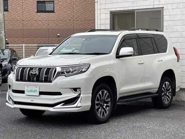 トヨタ ランドクルーザー プラド TX Lパッケージ 福岡県 2022(令4)年 2.6万km ホワイトパールクリスタルシャイン ワンオーナー/ルーフレール/ムーンルーフ/サイドステップ/全席黒レザーシート(合皮)/モデリスタエアロ【フロント・リア・マフラー】/TRDインナーステップガーニッシュ/インナードアハンドルカバー/純正９インチメモリナビ/【AM/FM/Bluetooth/USB/フルセグTV】/パノラミックビューモニター/ビルトインETC2.0/パワーシート(D/N席)/シートヒーター(D/N席)/エアーシート(D/N席)/トヨタセーフティセンス/・PCS(プリクラッシュセーフティ)/・LDA(レーンディパーチャーアラート)ヨーアシスト機能付き/・ふらつき警報機能/・車線逸脱警報機能/・車線逸脱抑制機能/・AHB(オートマチックハイビーム)/・RSA(ロードサインアシスト)/・レーダークルーズコントロール(全車速追従機能付き)/・先行車発進告知機能/BSM(ブラインドスポットモニター)/PKSB(パーキングサポートブレーキ)/ウィンドシールドデアイサー/社外デジタルインナーミラー型前後ドライブレコーダー(GPS付き)CELLSTAR【TZ-D203MW】/純正フロアマット/純正１５インチアルミホイール/スペアキー×１/ドアバイザー/取扱説明書/保証書