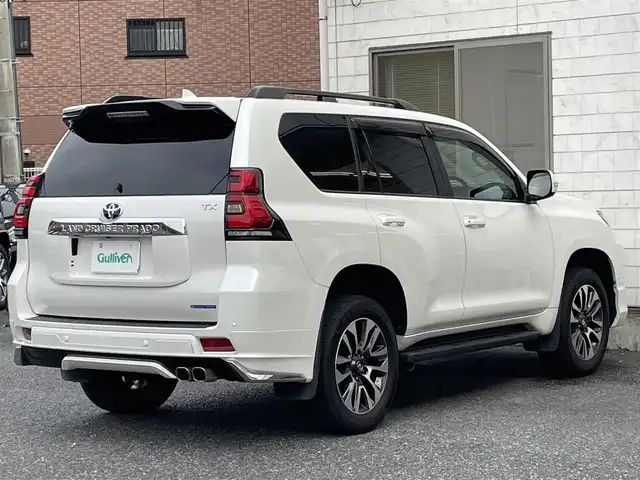 トヨタ ランドクルーザー プラド TX Lパッケージ 福岡県 2022(令4)年 2.6万km ホワイトパールクリスタルシャイン ワンオーナー/ルーフレール/ムーンルーフ/サイドステップ/全席黒レザーシート(合皮)/モデリスタエアロ【フロント・リア・マフラー】/TRDインナーステップガーニッシュ/インナードアハンドルカバー/純正９インチメモリナビ/【AM/FM/Bluetooth/USB/フルセグTV】/パノラミックビューモニター/ビルトインETC2.0/パワーシート(D/N席)/シートヒーター(D/N席)/エアーシート(D/N席)/トヨタセーフティセンス/・PCS(プリクラッシュセーフティ)/・LDA(レーンディパーチャーアラート)ヨーアシスト機能付き/・ふらつき警報機能/・車線逸脱警報機能/・車線逸脱抑制機能/・AHB(オートマチックハイビーム)/・RSA(ロードサインアシスト)/・レーダークルーズコントロール(全車速追従機能付き)/・先行車発進告知機能/BSM(ブラインドスポットモニター)/PKSB(パーキングサポートブレーキ)/ウィンドシールドデアイサー/社外デジタルインナーミラー型前後ドライブレコーダー(GPS付き)CELLSTAR【TZ-D203MW】/純正フロアマット/純正１５インチアルミホイール/スペアキー×１/ドアバイザー/取扱説明書/保証書